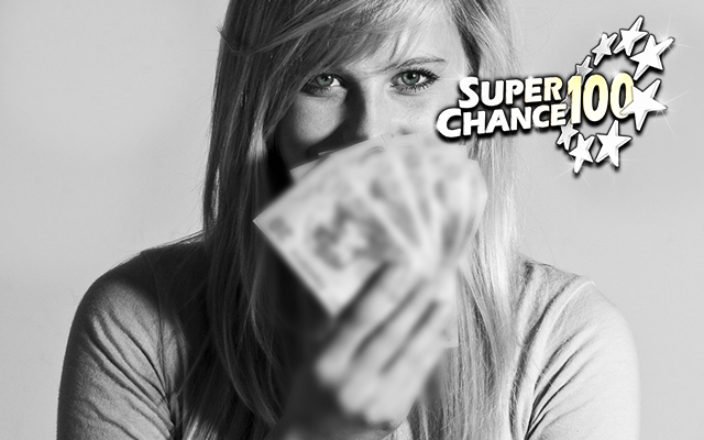 Photographie d'une femme en train de cacher son sourire derrière un éventail de billets de banque.